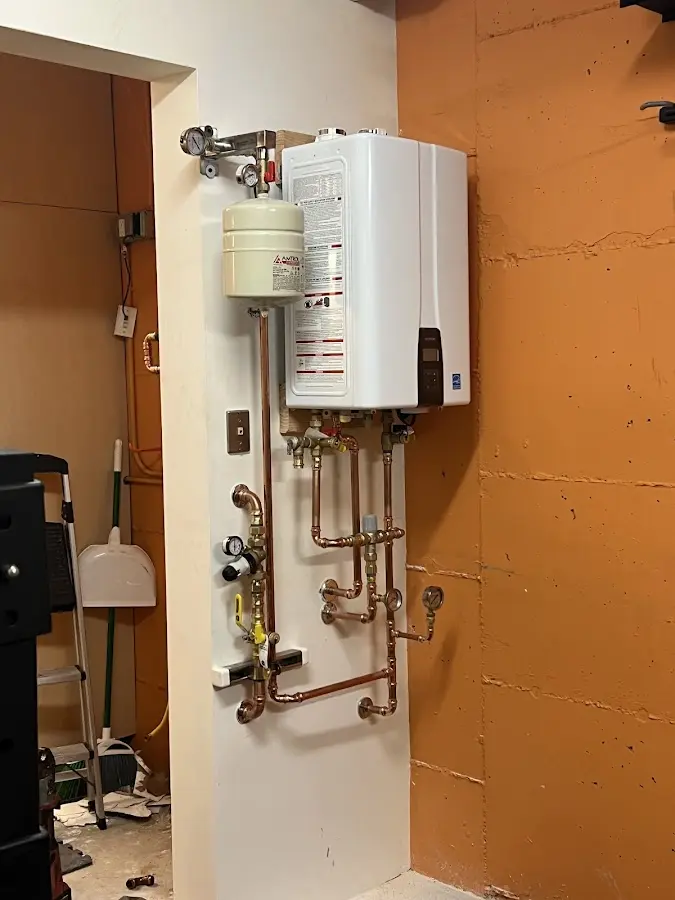 Plumbing technician inspecting water heater connections in Val Verde